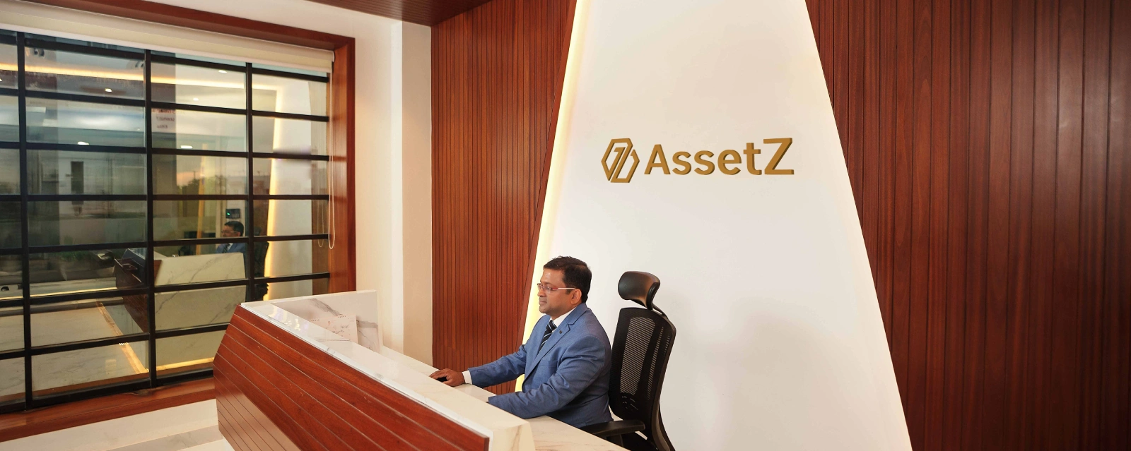 Professional seated at the AssetZ Premier reception or front desk