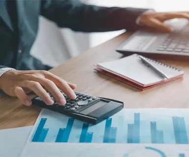 Entrepreneur reviewing financial charts with calculator